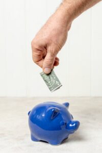 hand-putting-bank-note-piggy-bank_23-2148305920